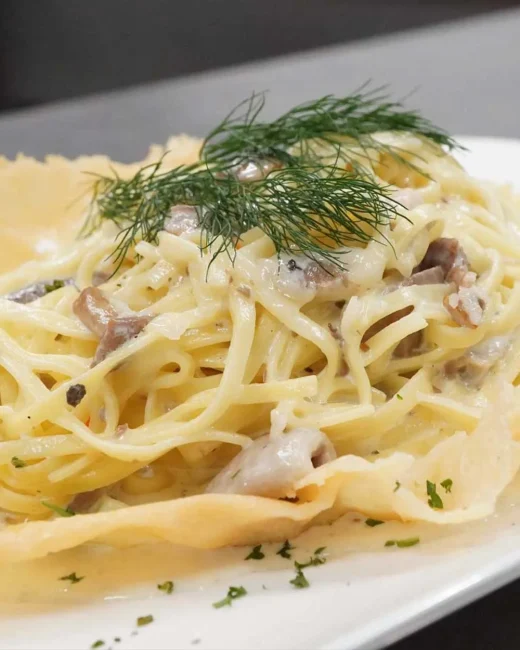 Pasta alla Forma – Feine Bandnudeln in Sahne-Trüffel-Sauce mit Grana Padano auf Rucola-Waldpilz-Bett.